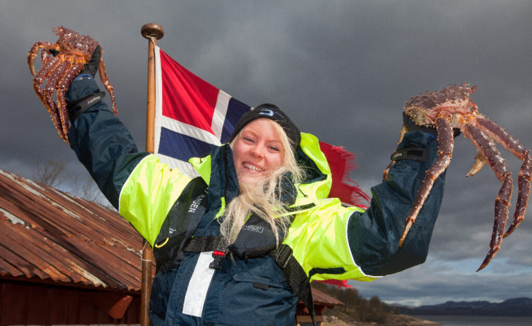 A woman holds king crabs